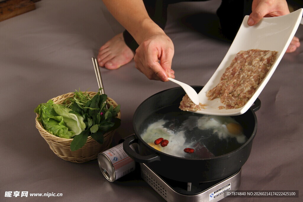 烹饪者往锅中倒入食材