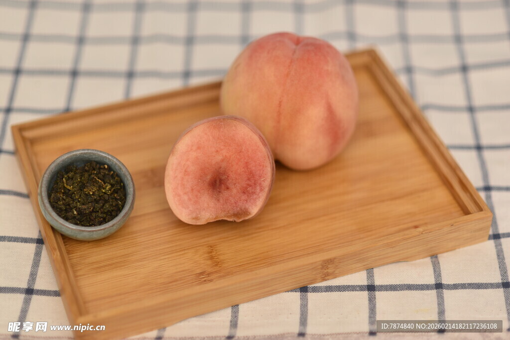 木盘上的鲜桃与一小碟茶叶