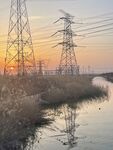 夕阳下的输电塔与河道