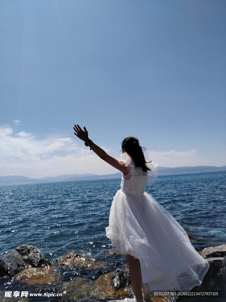 海边白裙女子舒展身姿