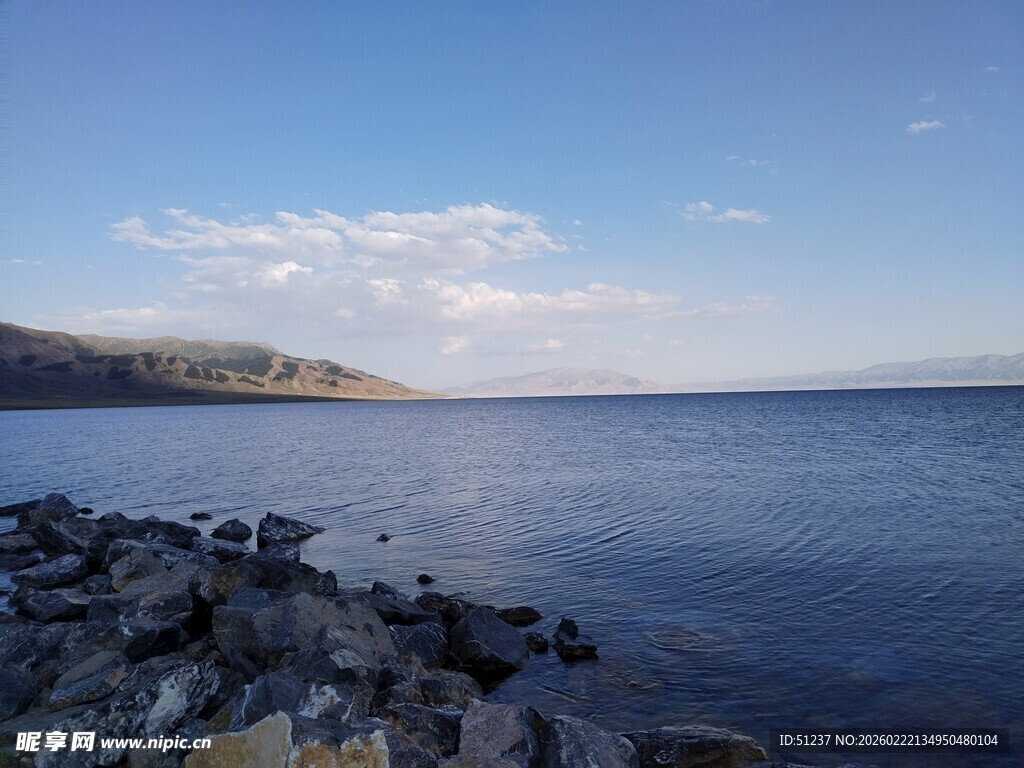 宁静湖畔的岩石与蓝天