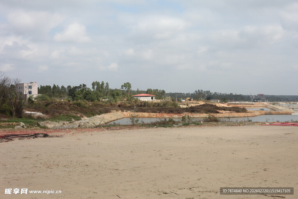 空旷沙滩与远处绿植景观