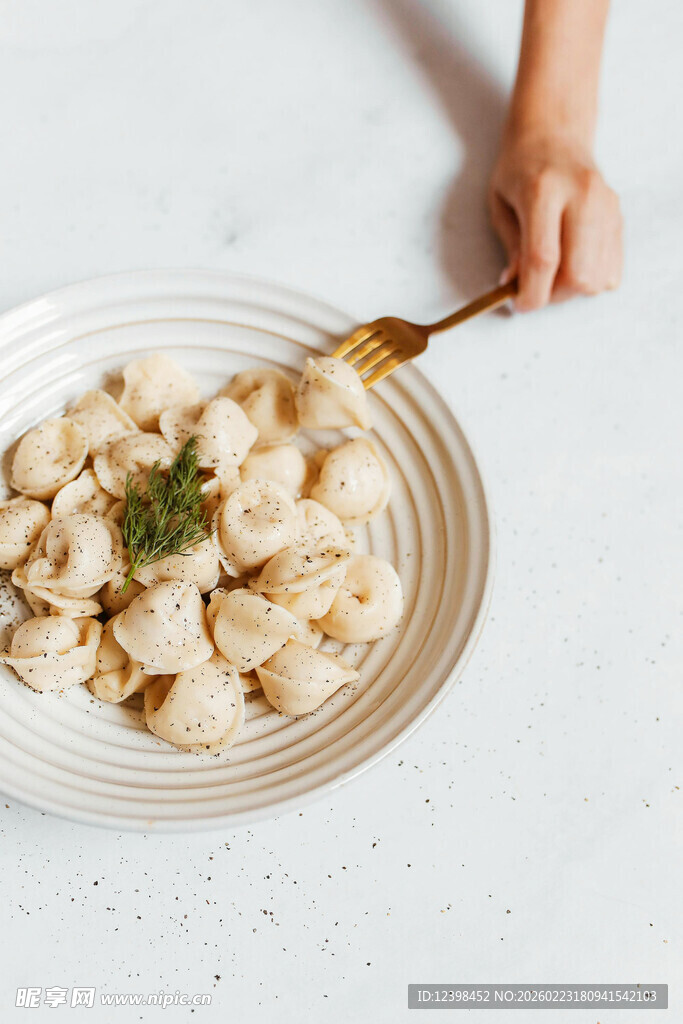 手持叉子享用盘中面食