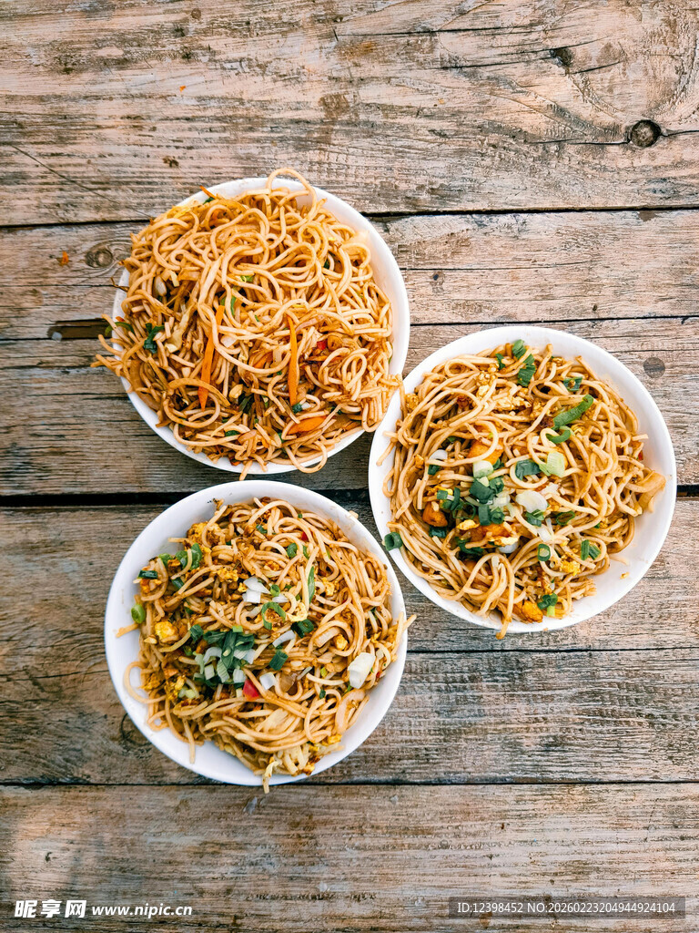 三碗美味炒面摆于木桌