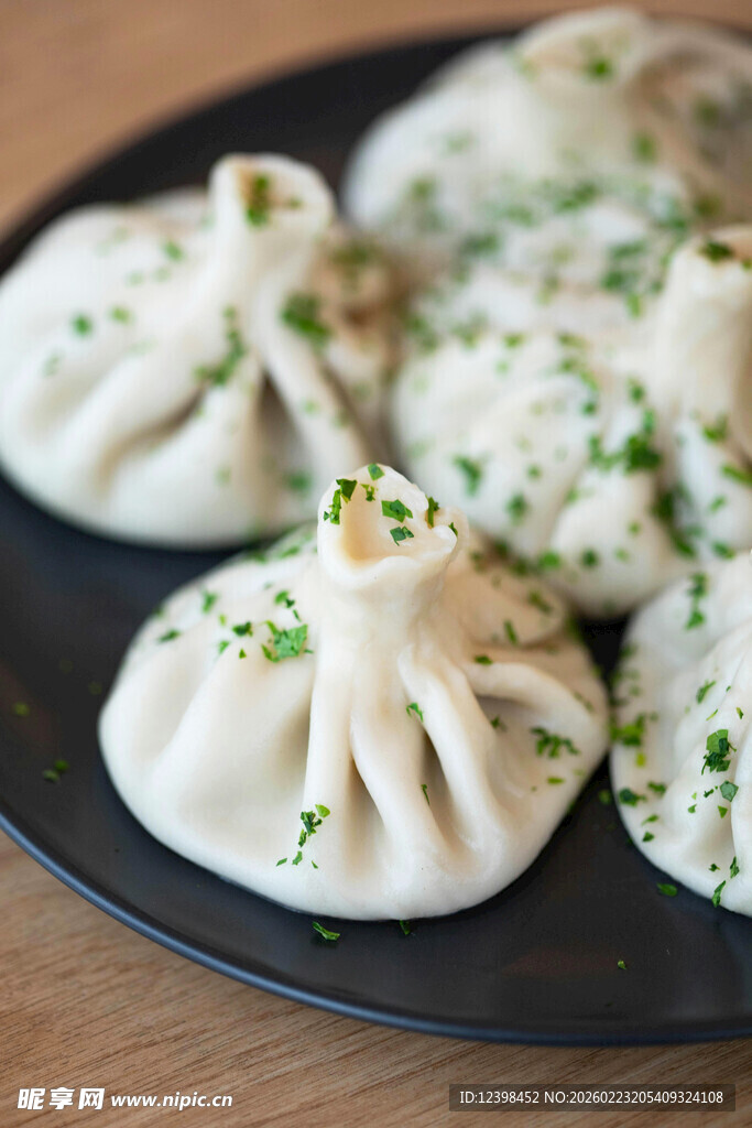 美味饺子摆于黑色盘中