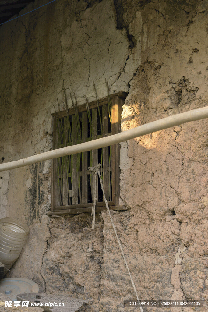 破旧土墙带铁栏的窗户