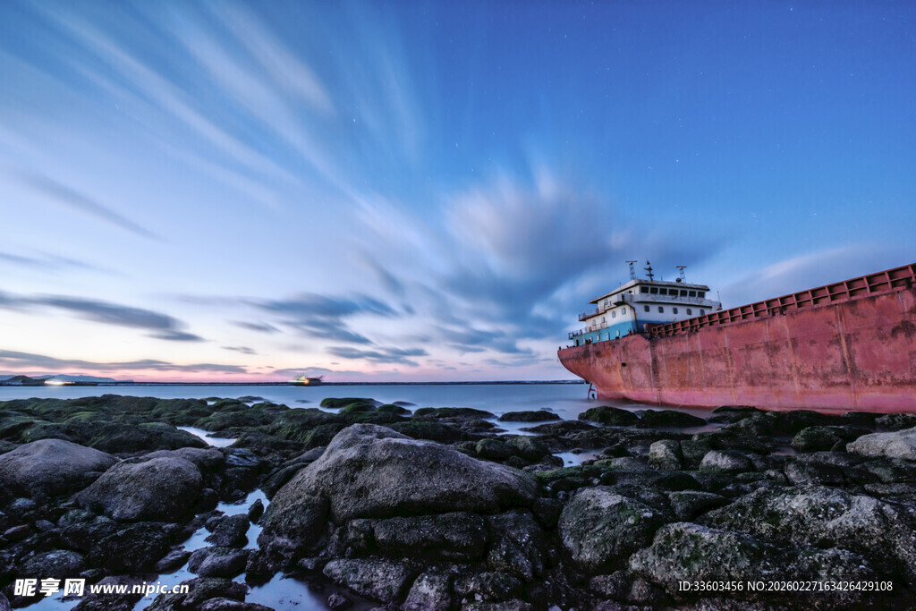 海边红船与礁石的美景