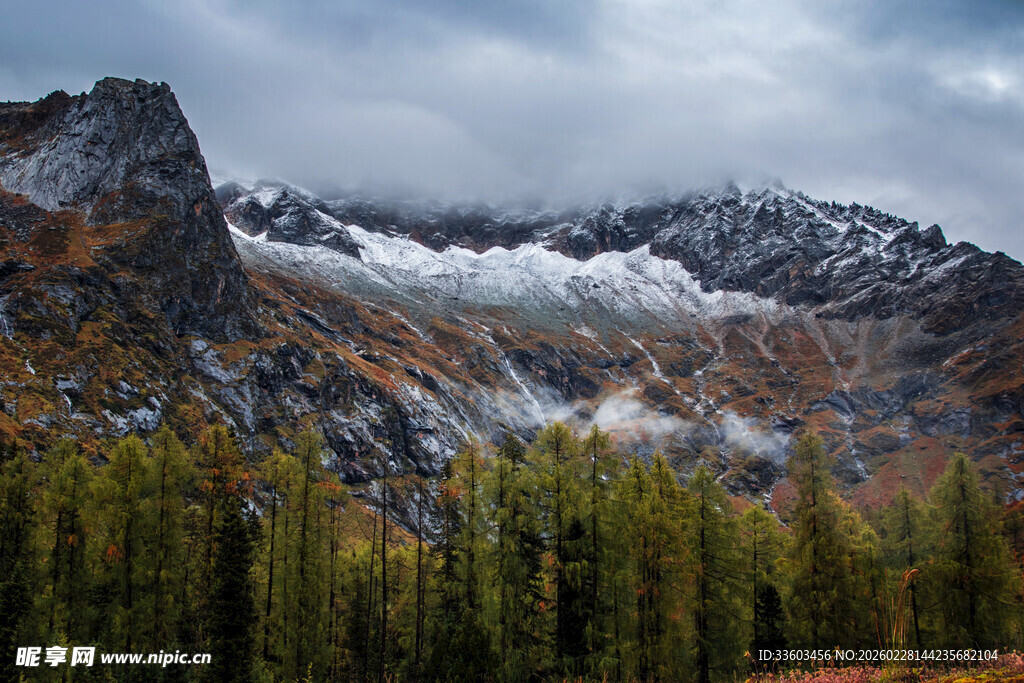 秋日山林环绕的巍峨雪山