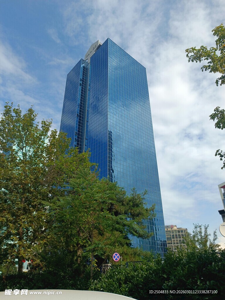 城市中高耸的蓝色玻璃大楼