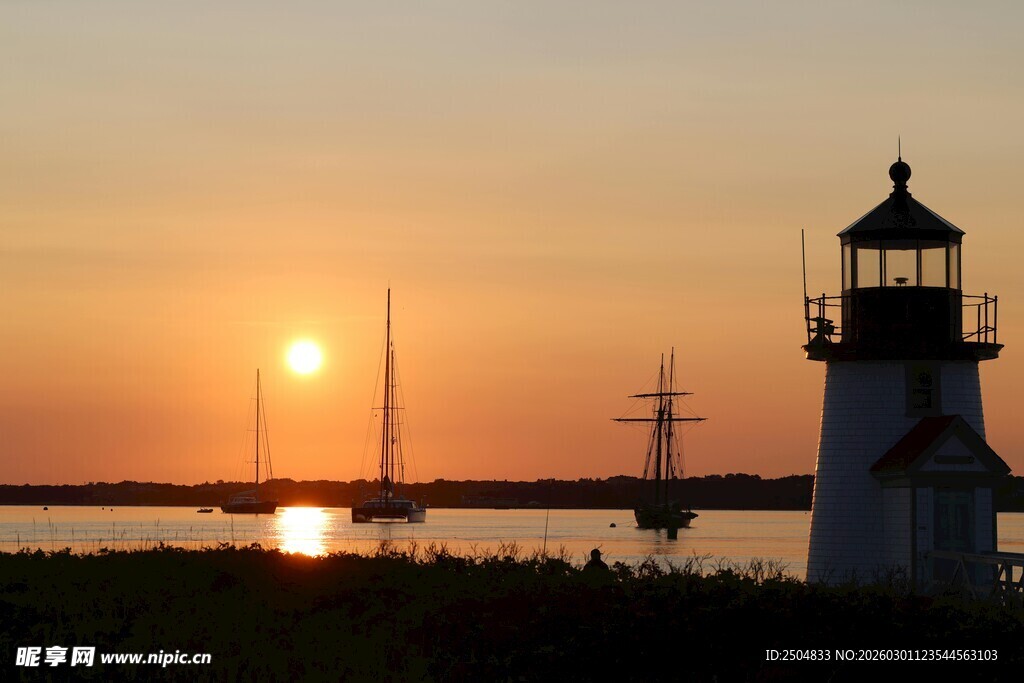 日落时分的灯塔与帆船