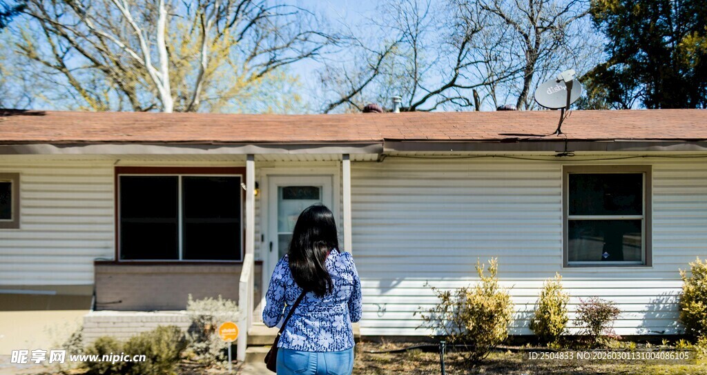 女子立于简约白色房屋前