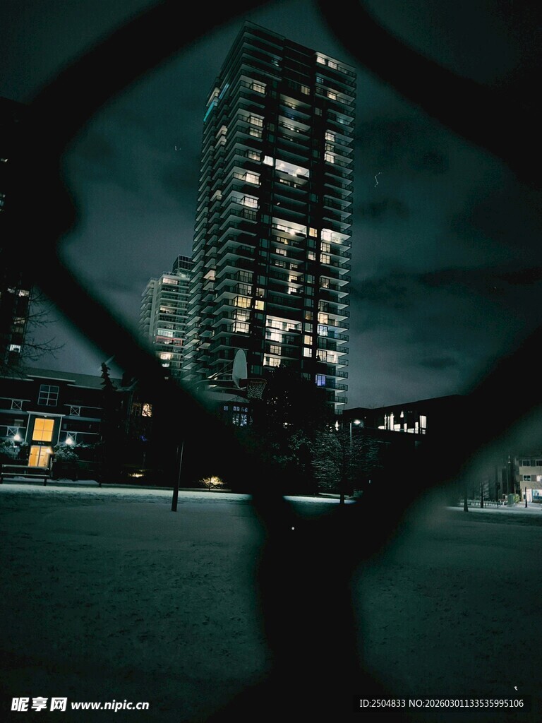 透过围栏看都市夜景