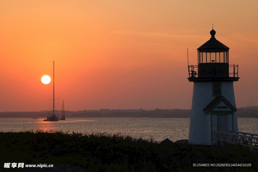 日落时分的灯塔与帆船