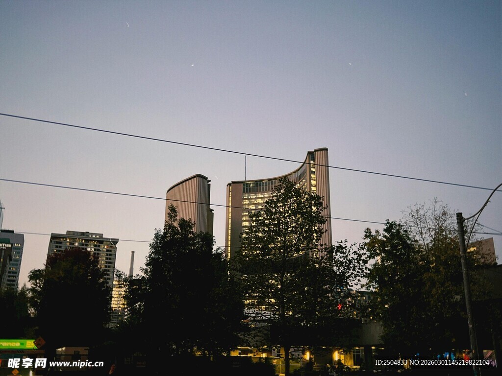 城市黄昏下的高楼与绿树