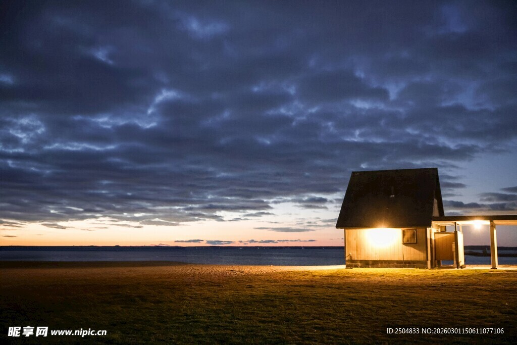 夜幕下旷野中的亮灯小屋