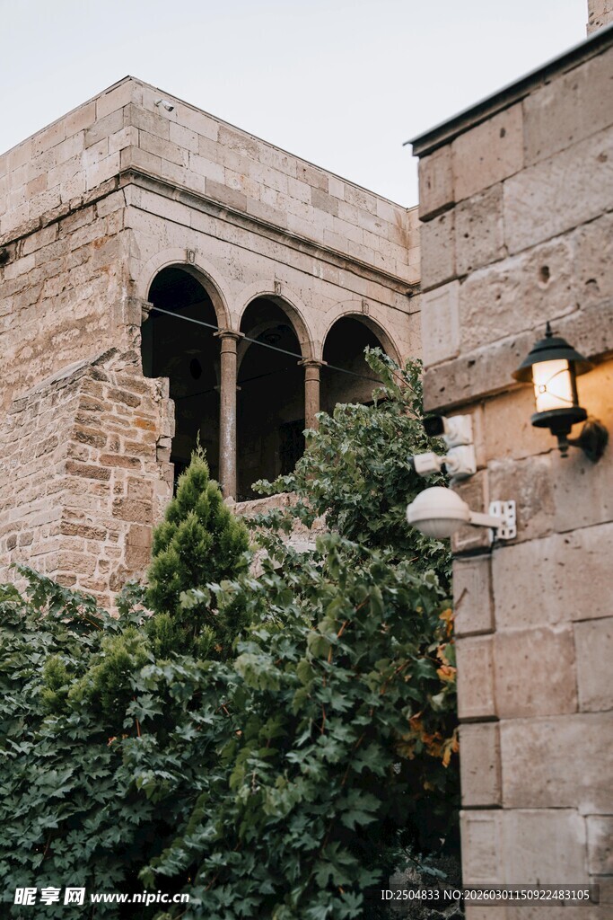古老建筑旁的绿植与壁灯