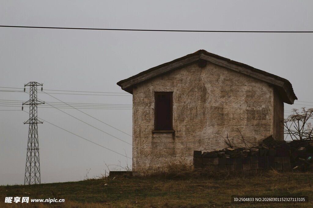 乡村小屋与远处电线塔