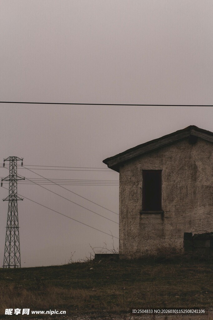荒野中的老旧小屋与电塔