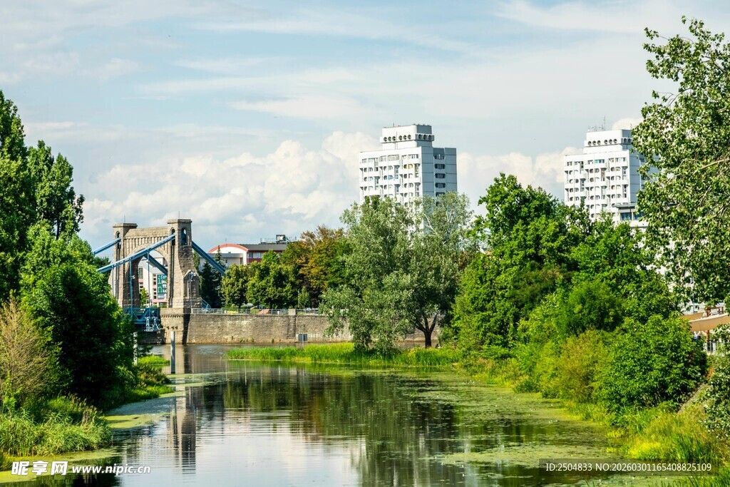 河畔绿树环绕的城市风光