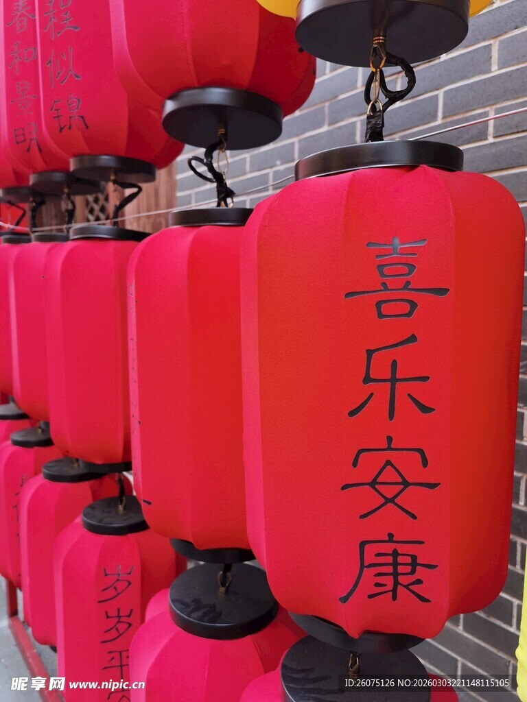 喜庆红灯笼挂于古朴砖墙