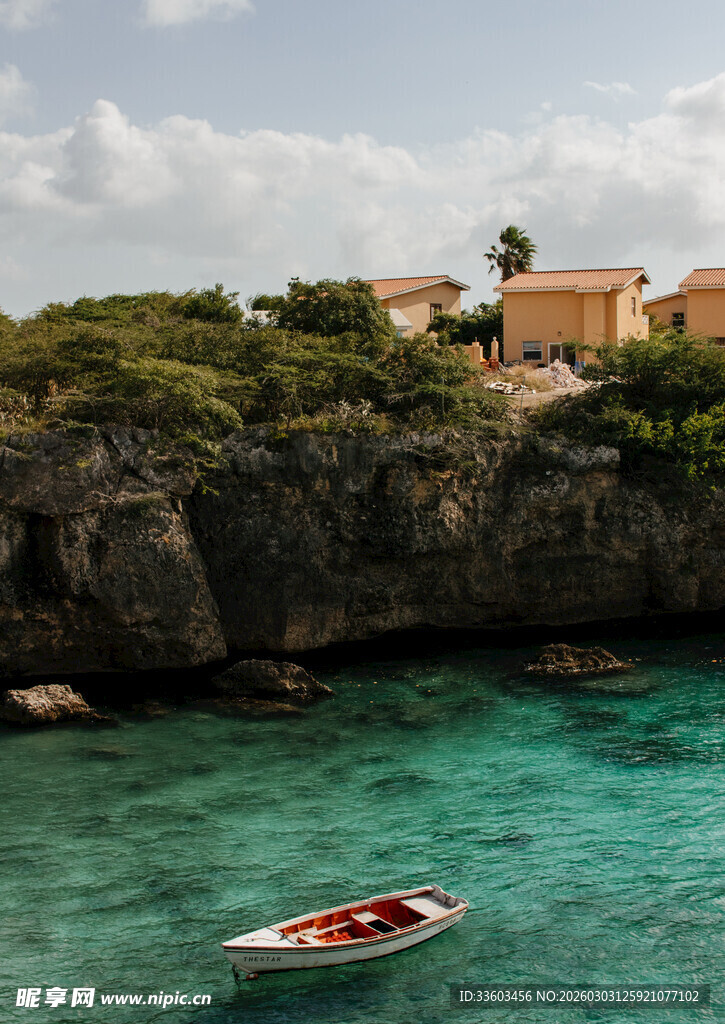 悬崖下的碧海小船与屋舍