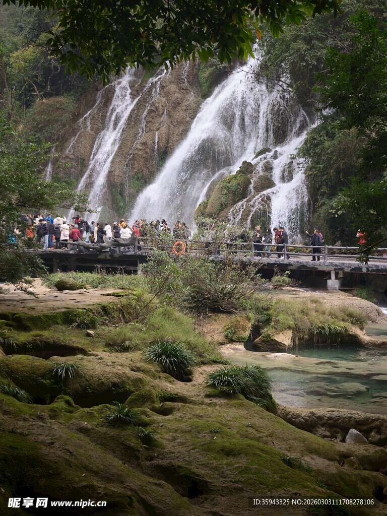 山间瀑布下的游人景致