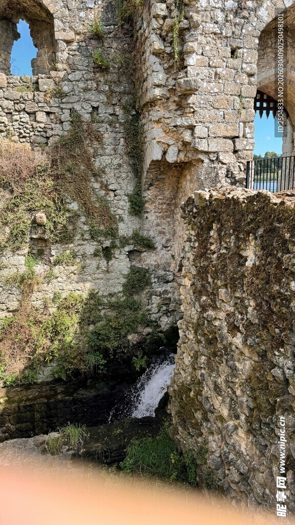 古老石墙下的潺潺溪流