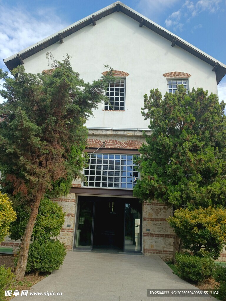 白色建筑前的绿树景观