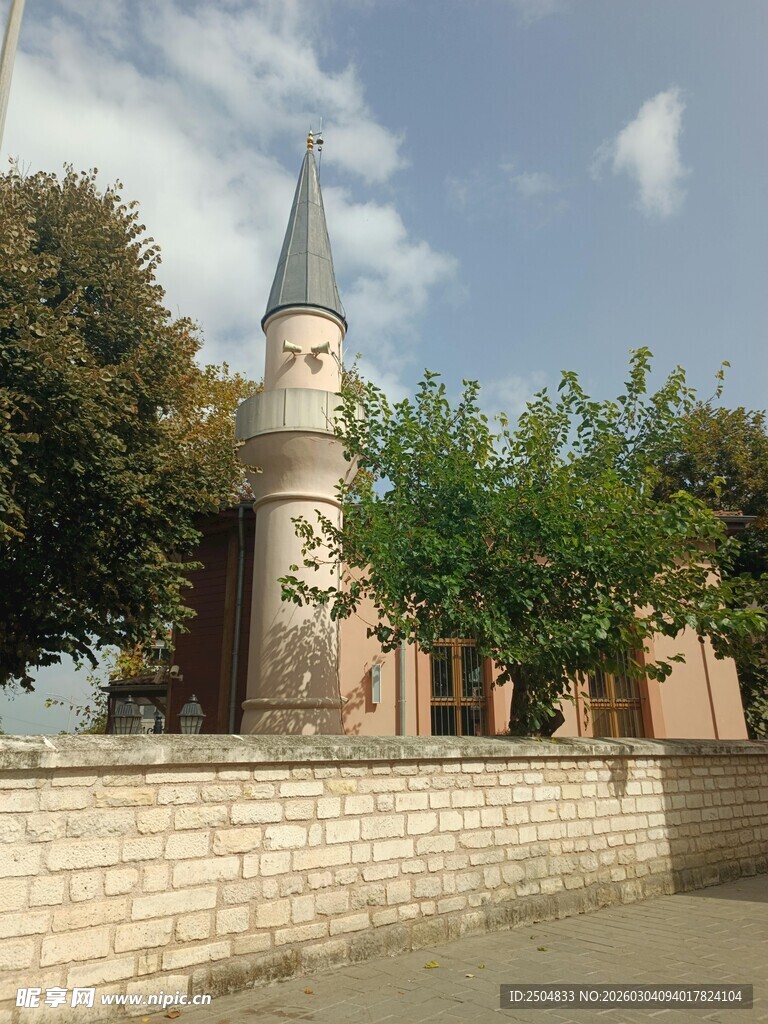 古老钟楼立于绿树环绕间