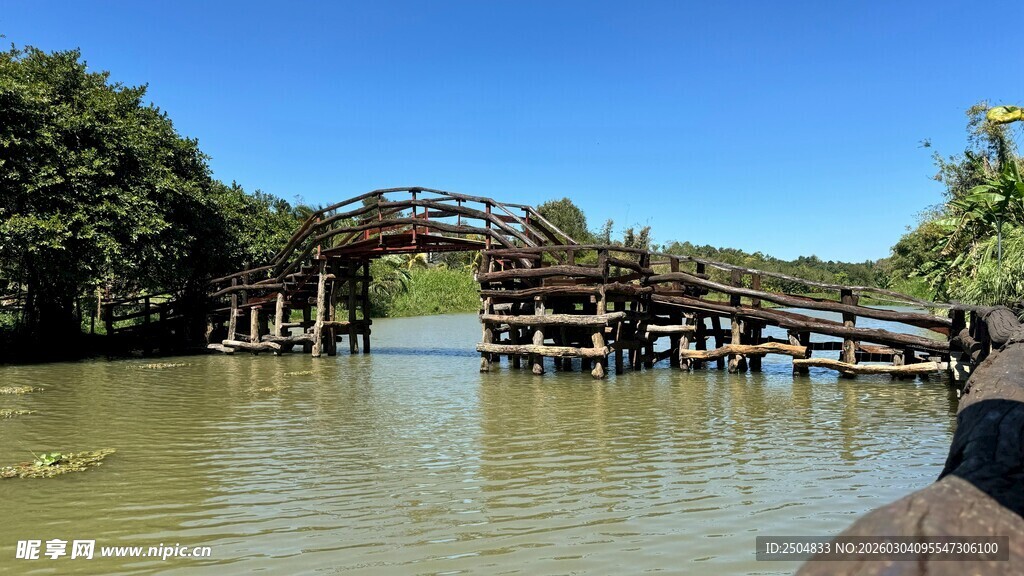 水上木桥横跨葱郁河岸