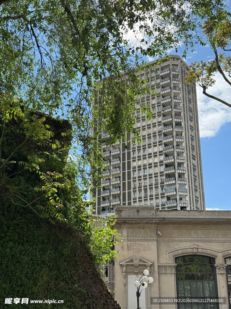 高楼旁绿植掩映的建筑