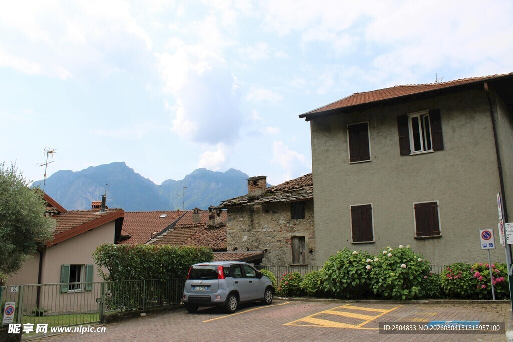 乡村住宅旁的车辆与远山