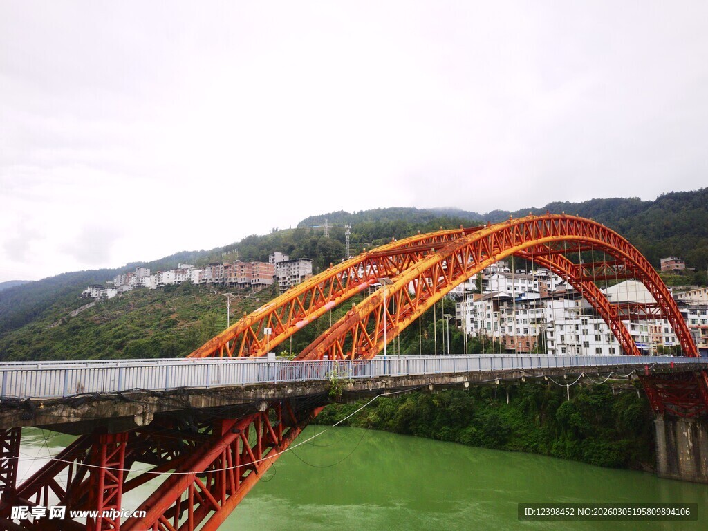 红色拱形大桥横跨绿水