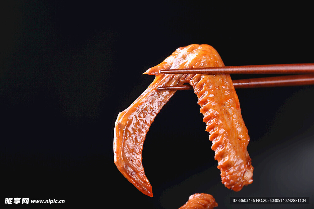 筷子夹起的美味卤鸭爪