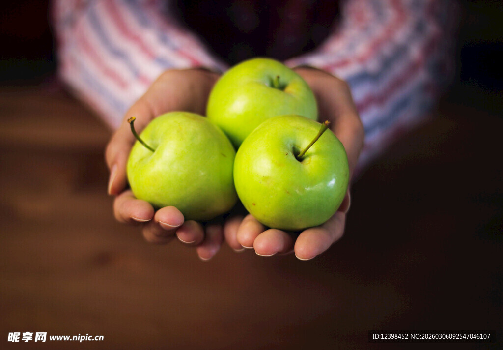 手中捧着三颗青苹果