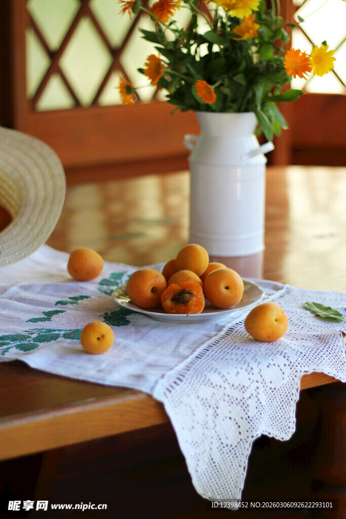 木桌布上的杏子与插花瓶