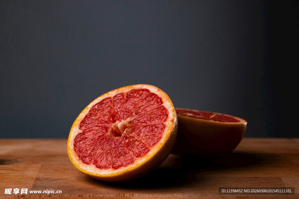 切开的红葡萄柚置于木桌