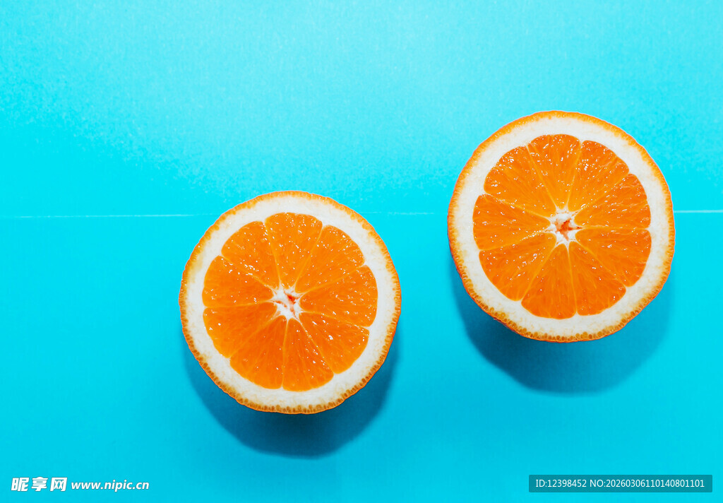 两半鲜橙置于蓝色背景