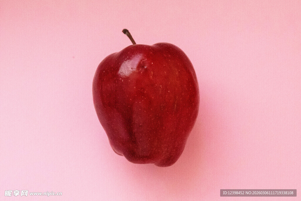粉红背景上的红苹果