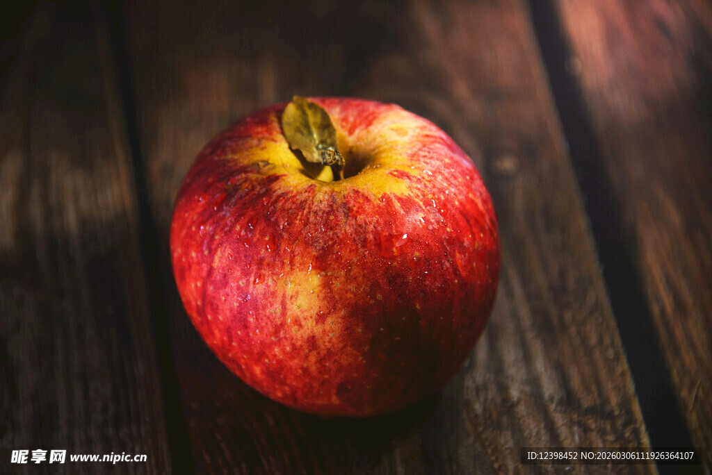 红苹果置于古朴木桌上