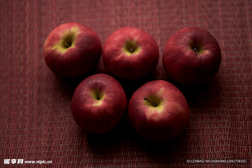 五个红苹果摆放在布面