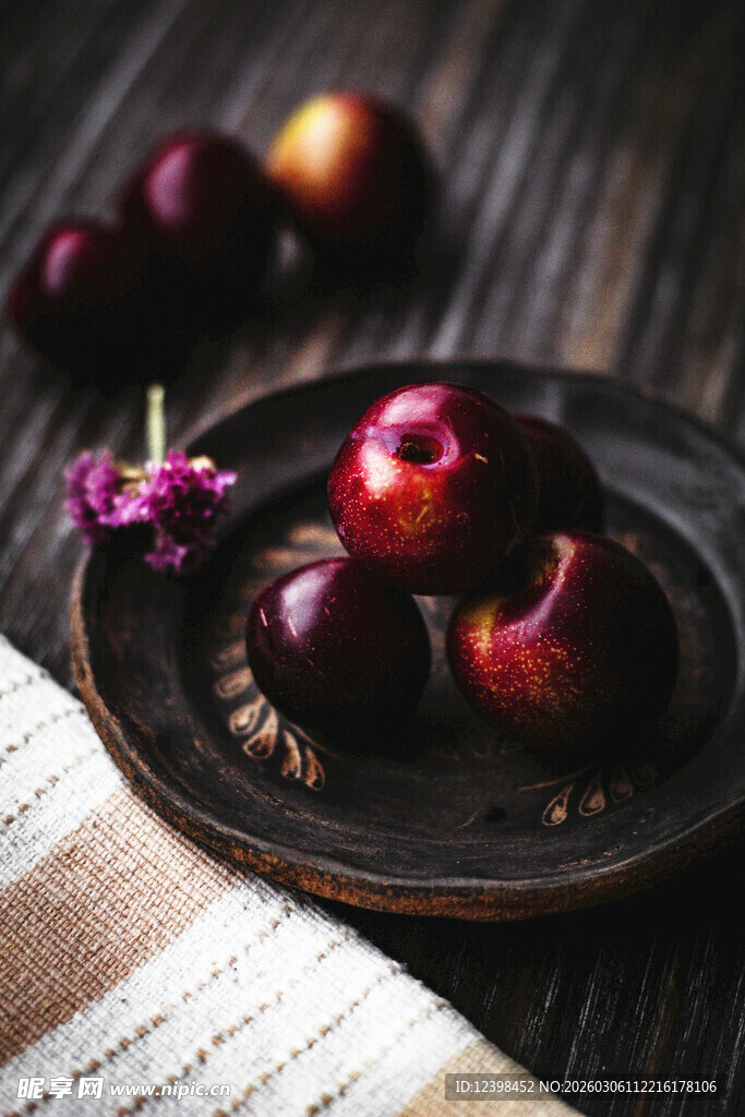 木盘上的新鲜李子与花朵