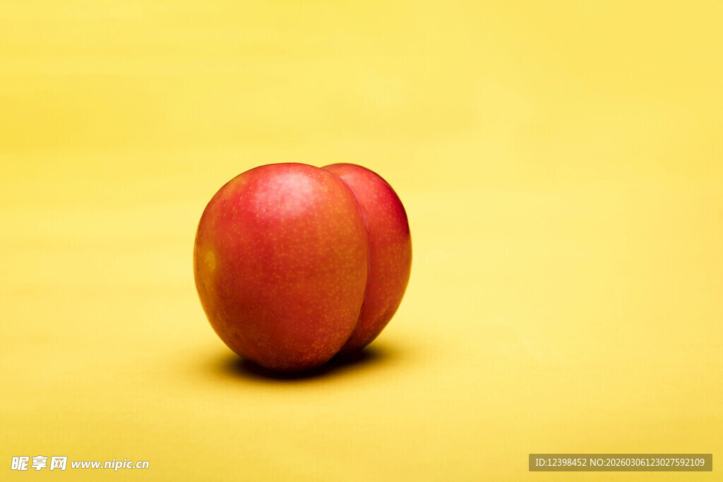 黄色背景上的一颗红李子