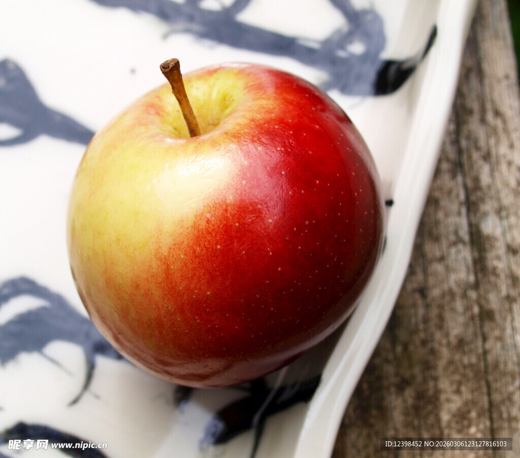 红黄色苹果置于花纹盘上