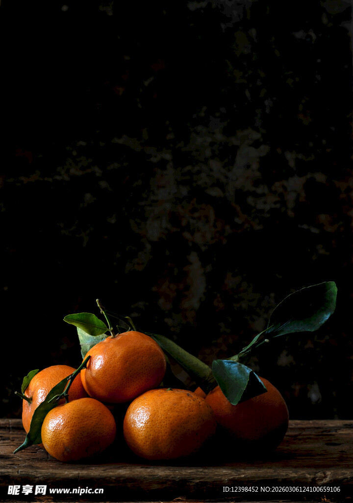 木桌上的新鲜带叶小橘子
