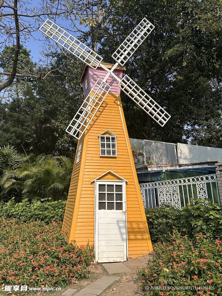 橙色风车立于花丛中