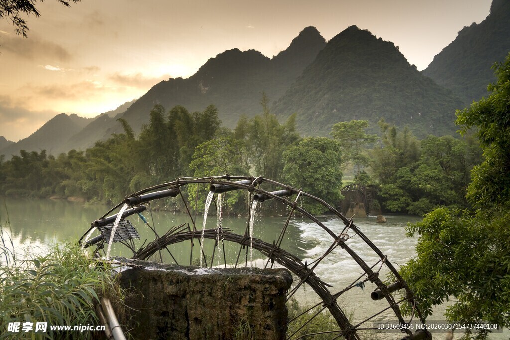 河畔水车伴山景的美丽画面