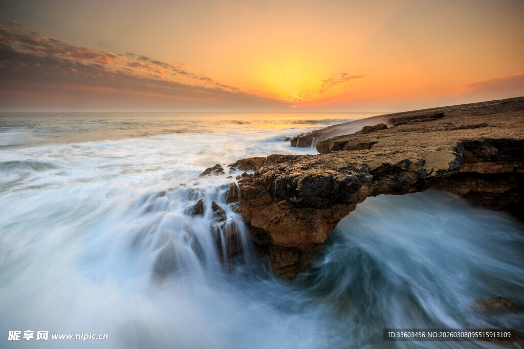 海边日落时的激浪岩石
