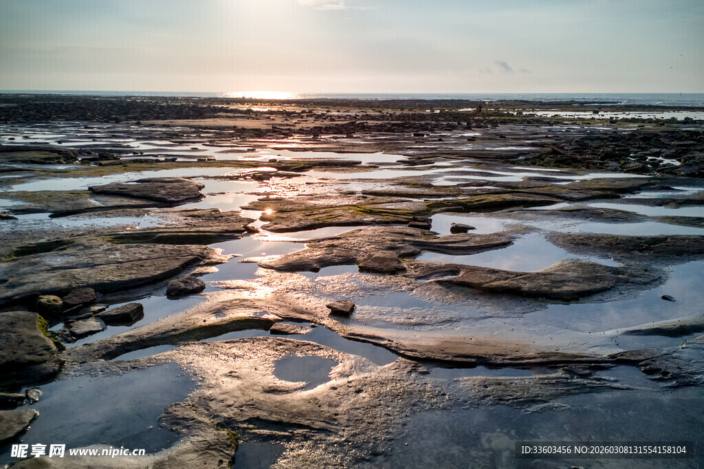 夕阳下的海边礁石景观