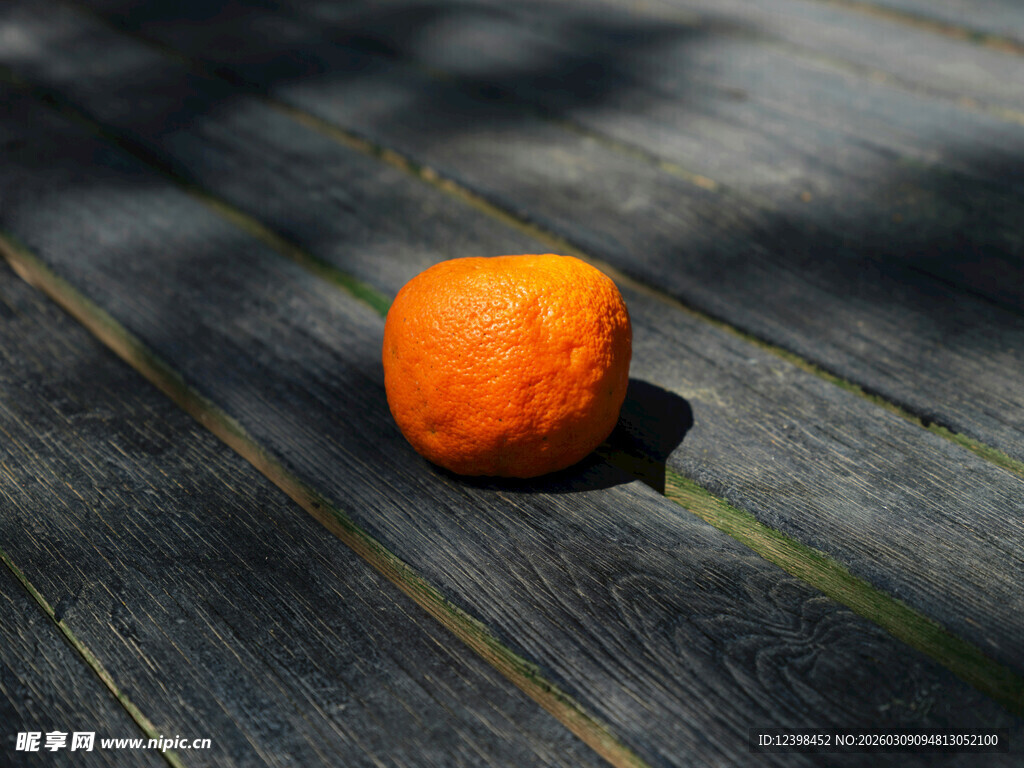 木桌上的一颗橙色橘子